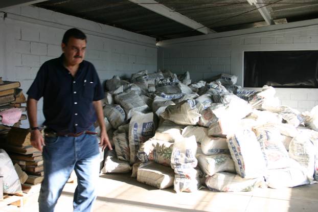 Hundreds of sacks of Guatemalan secret police documents stacked with a man in the foreground.